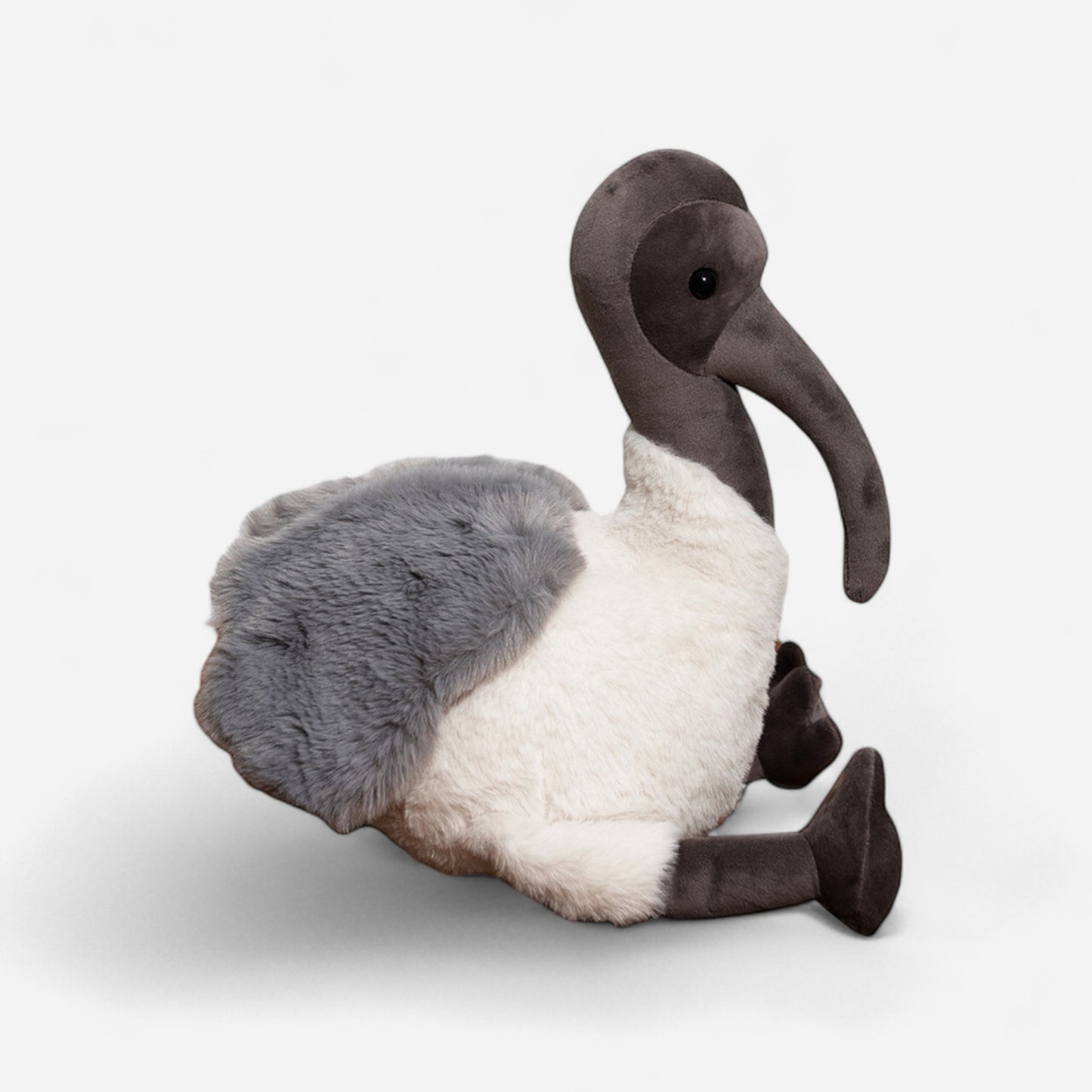 Plush toy Australian bird Ibis with grey and white feathers on a light grey background